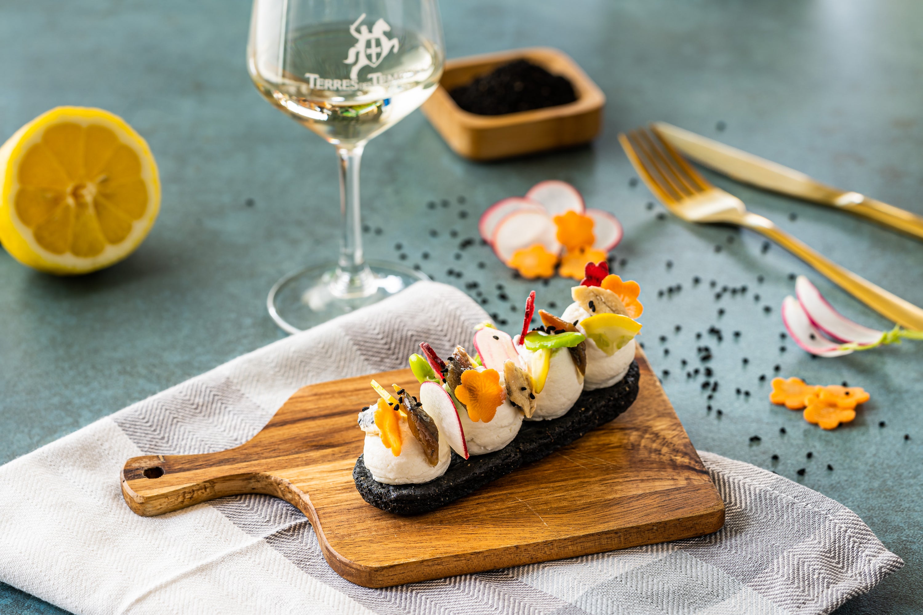 Sablé à l'encre de seiche, mousse de chèvre frais, anchois et petits légumes
